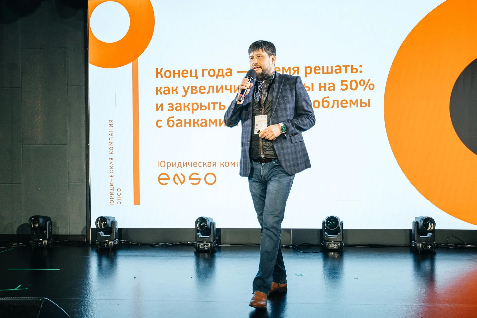 Две женщины позируют на фоне золотого текстильного шатра с длинной бахромой; вокруг — хвойные ветви и подсвеченные гирляндами деревья.